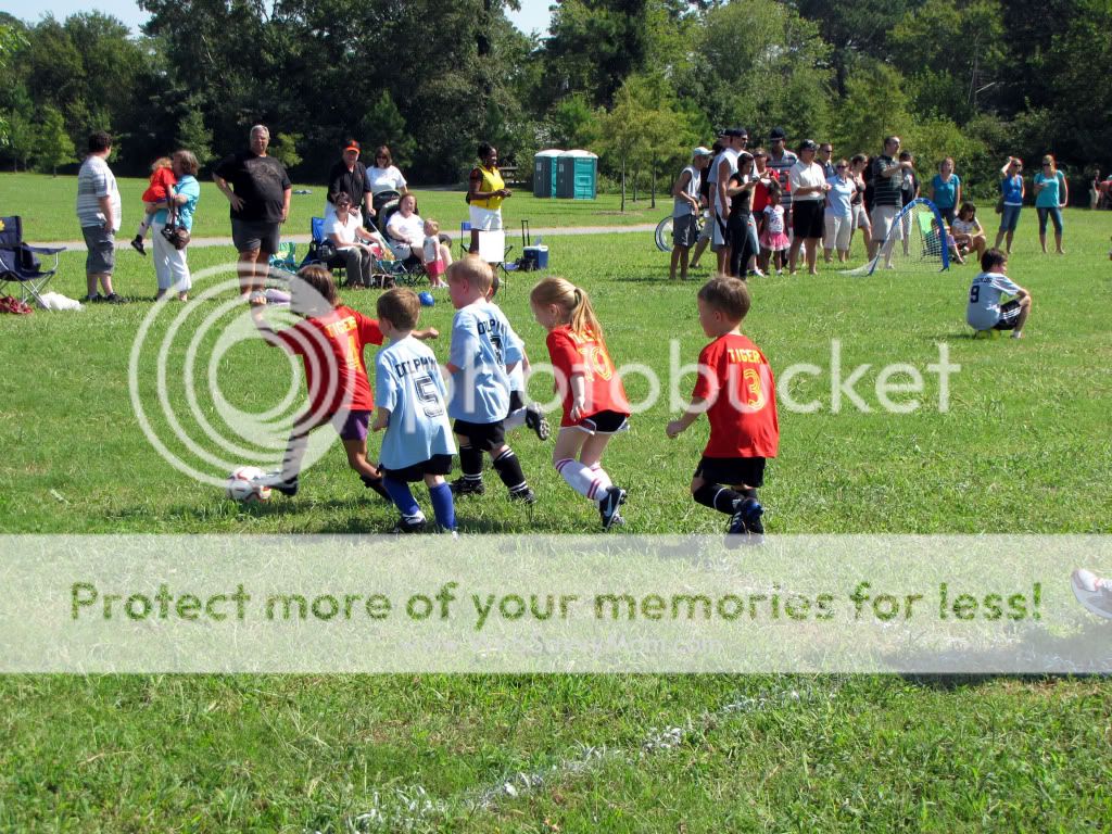 The 4-year olds running after the Soccer ball